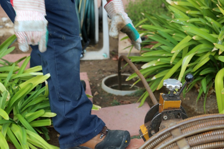 Plumber cleaning clogged sewer line