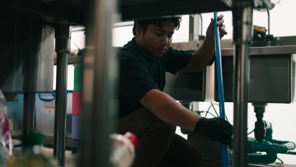 Commercial plumber working on pipes